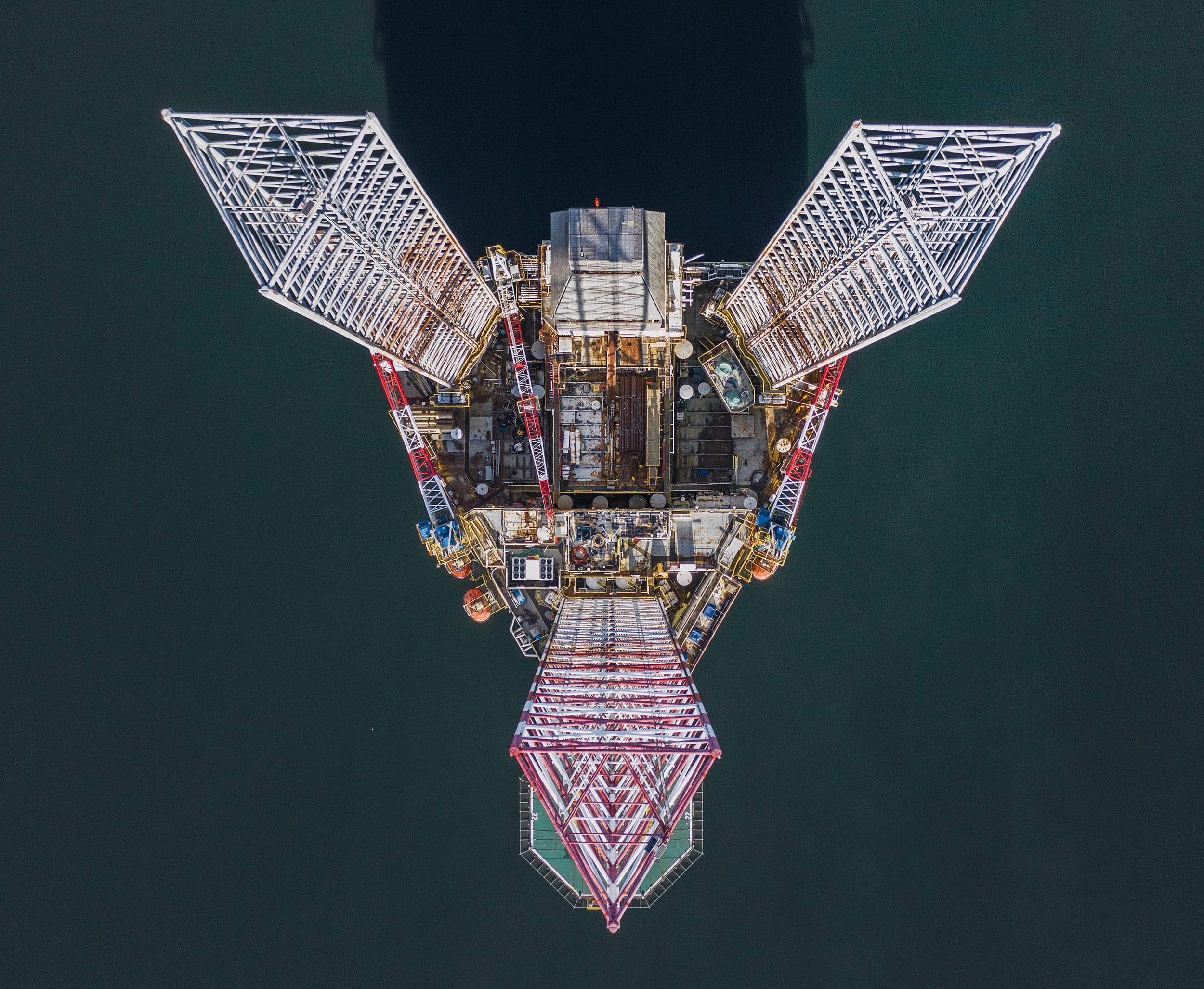 Aerial shot looking down an an Offshore oil platform and its shadow, Cromarty Firth, Scotland, United Kingdom